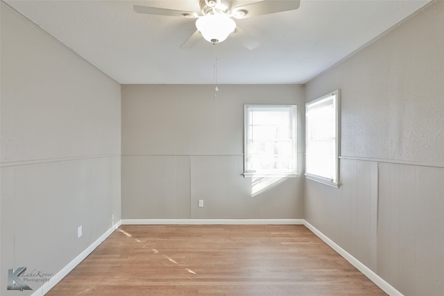 4158 Russell Ave, Abilene, TX 79605 - spare room featuring wainscoting, light wood-style flooring, baseboards, and ceiling fan