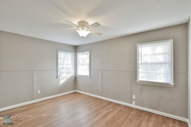 4158 Russell Ave, Abilene, TX 79605 - empty room featuring wood finished floors, baseboards, a ceiling fan, and a wainscoted wall