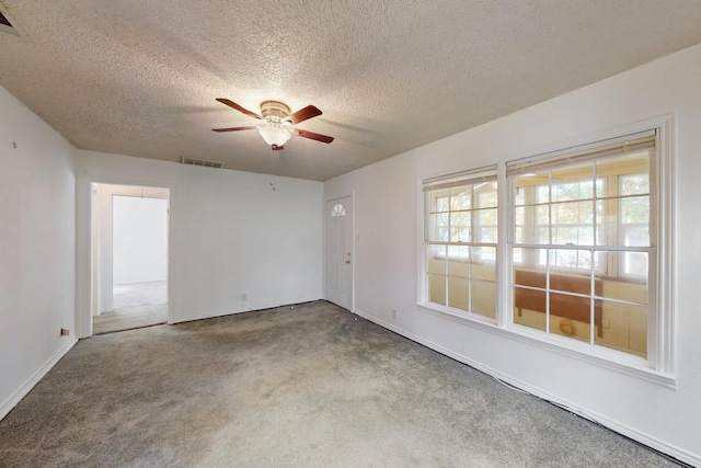 carpeted empty room with baseboards, a textured ceiling, and ceiling fan