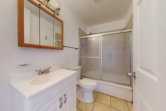bathroom with toilet, vanity, and tile patterned floors