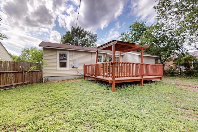 rear view of house featuring a pergola, a lawn, fence, and a deck