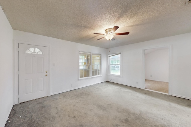 carpeted empty room with ceiling fan, baseboards, a textured ceiling, and visible vents