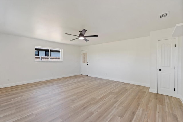 empty room with visible vents, light wood-type flooring, baseboards, and ceiling fan