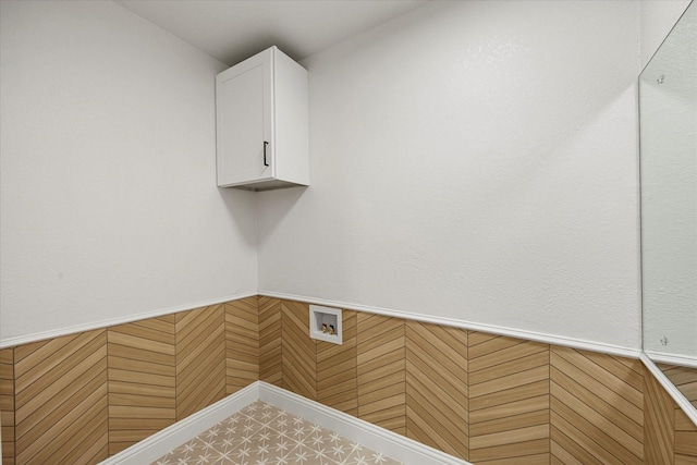 laundry area featuring cabinet space, a wainscoted wall, and hookup for a washing machine