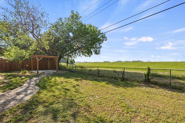 view of yard featuring a fenced backyard, a gazebo, and a rural view