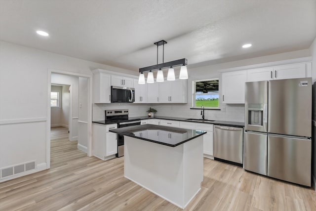 kitchen featuring stainless steel appliances, tasteful backsplash, visible vents, and a sink