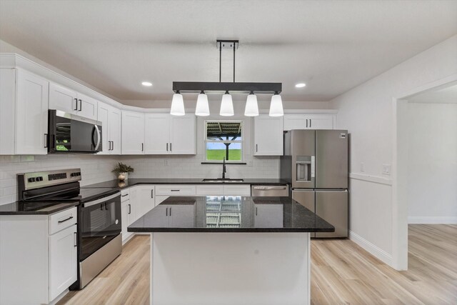 kitchen with white cabinets, light wood finished floors, a sink, and appliances with stainless steel finishes