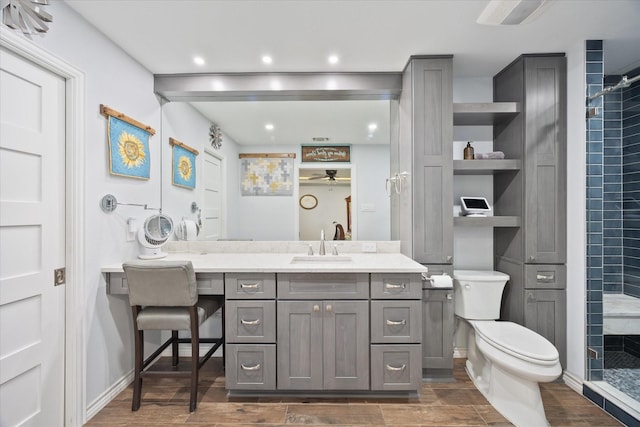 813 Grinnell Dr, Richardson, TX 75081 - full bathroom with tiled shower, wood finished floors, vanity, ceiling fan, and toilet
