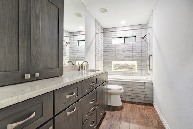 813 Grinnell Dr, Richardson, TX 75081 - bathroom featuring toilet, hardwood / wood-style flooring, tiled shower / bath combo, and vanity