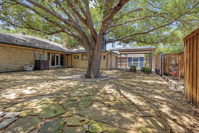 813 Grinnell Dr, Richardson, TX 75081 - back of property with a fenced backyard, brick siding, and a patio