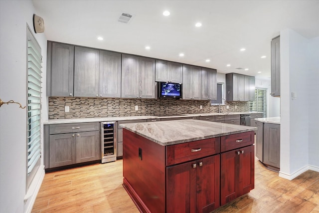 813 Grinnell Dr, Richardson, TX 75081 - kitchen with beverage cooler, backsplash, light wood finished floors, light stone counters, and dishwasher