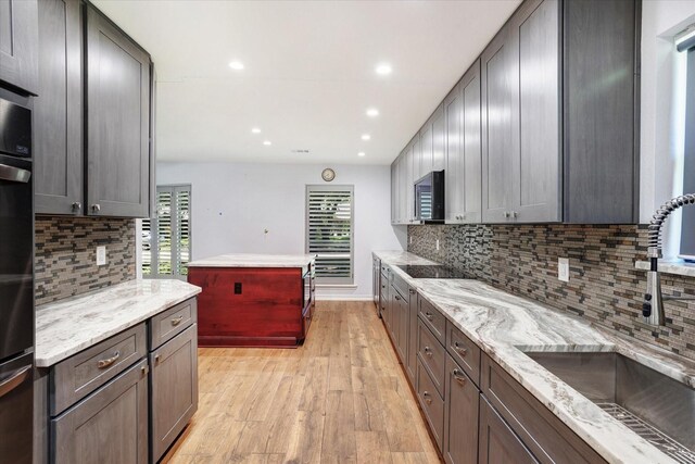 813 Grinnell Dr, Richardson, TX 75081 - kitchen with a sink, light wood-style flooring, backsplash, light stone counters, and recessed lighting