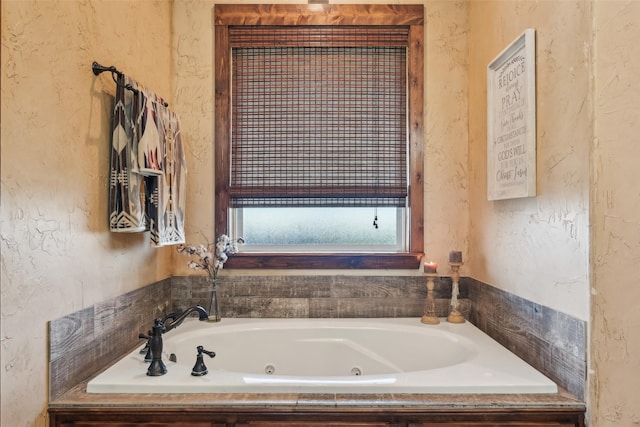 bathroom featuring a textured wall and a whirlpool tub