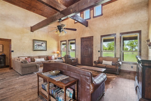 living area with beam ceiling, plenty of natural light, and a towering ceiling