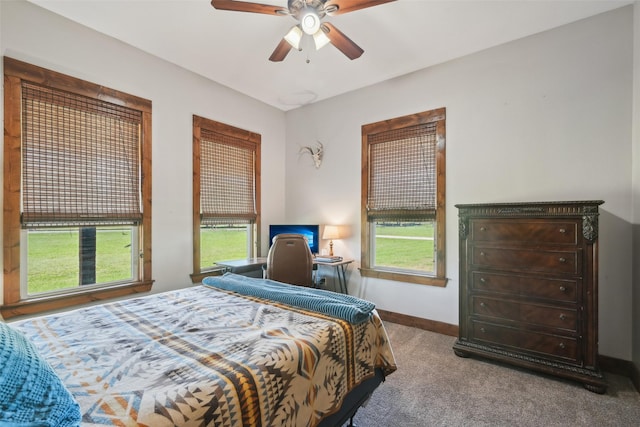 bedroom with carpet flooring, multiple windows, baseboards, and a ceiling fan