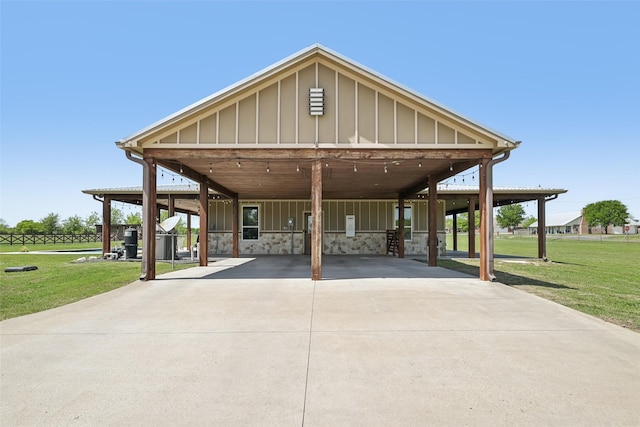 farmhouse-style home featuring a carport, driveway, board and batten siding, and a front lawn