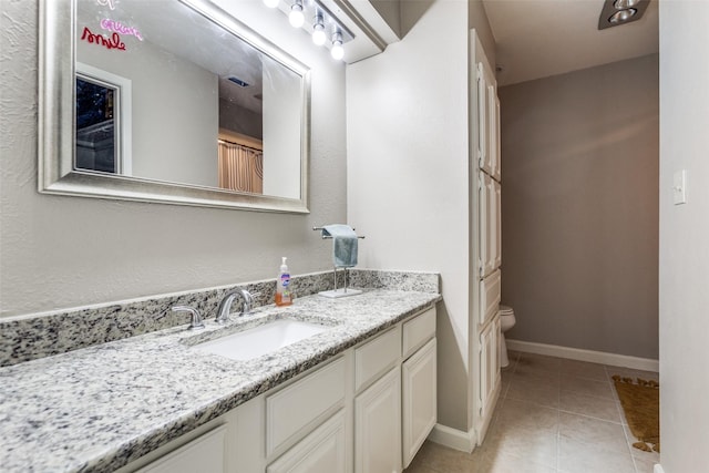 bathroom featuring vanity, baseboards, tile patterned flooring, toilet, and visible vents