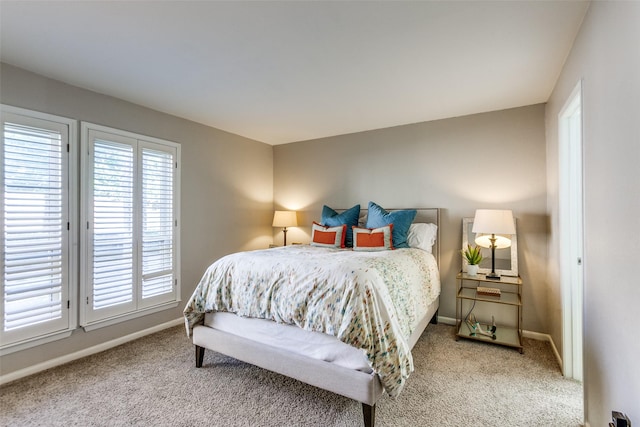 carpeted bedroom featuring access to exterior and baseboards