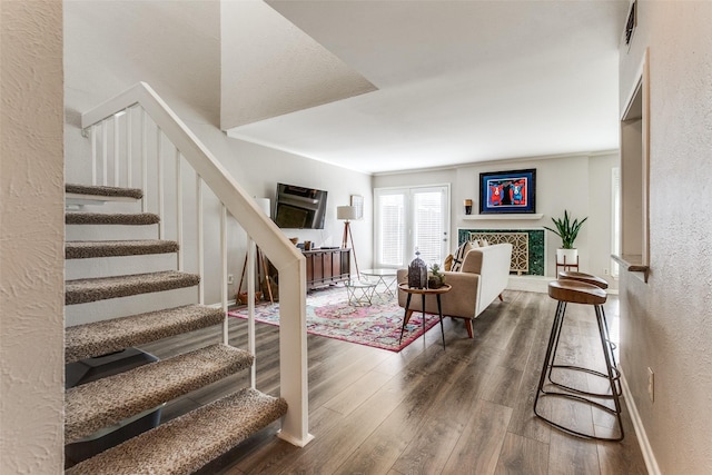 interior space with a textured wall, baseboards, and wood finished floors