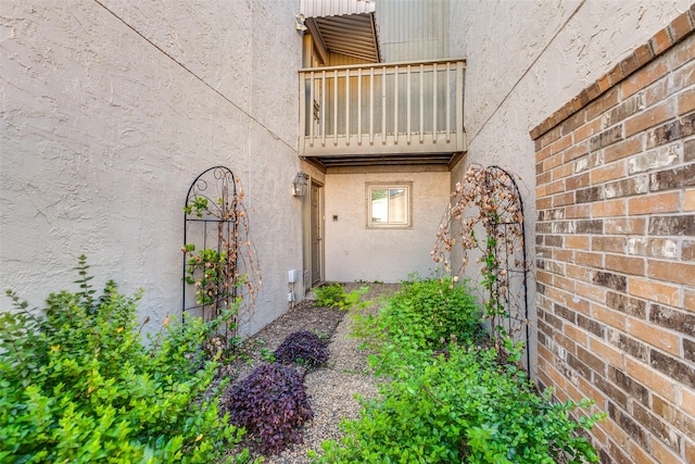 doorway to property with a balcony and stucco siding