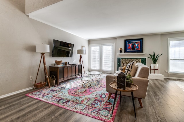 living room with ornamental molding, baseboards, a textured wall, and wood finished floors