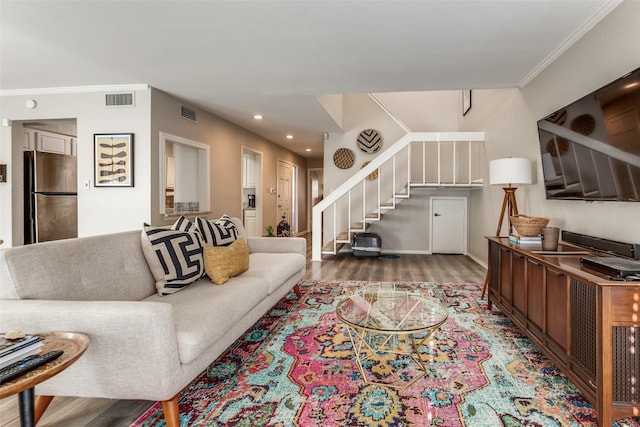 living area featuring visible vents, crown molding, recessed lighting, stairway, and wood finished floors