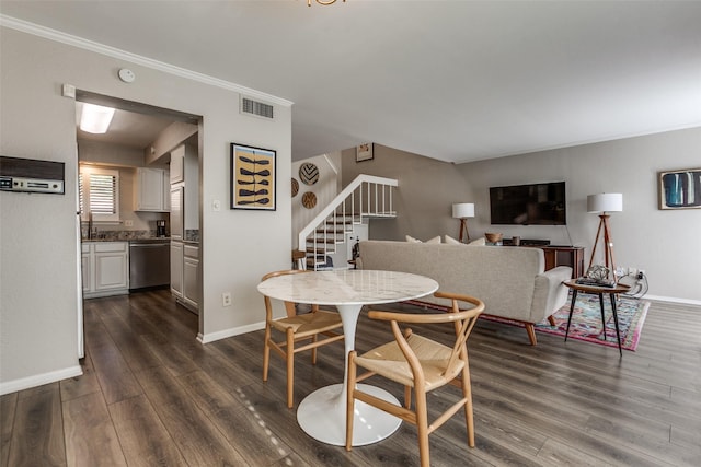 dining space featuring dark wood-type flooring, ornamental molding, visible vents, stairway, and baseboards