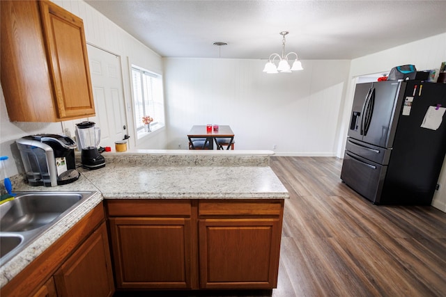 8820 Guadalupe Rd, Fort Worth, TX 76116 - kitchen featuring fridge with ice dispenser, an inviting chandelier, a peninsula, light countertops, and wood finished floors