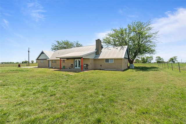 9518 County Road 913, Godley, TX 76044 - back of house with central AC unit, metal roof, a lawn, a chimney, and french doors