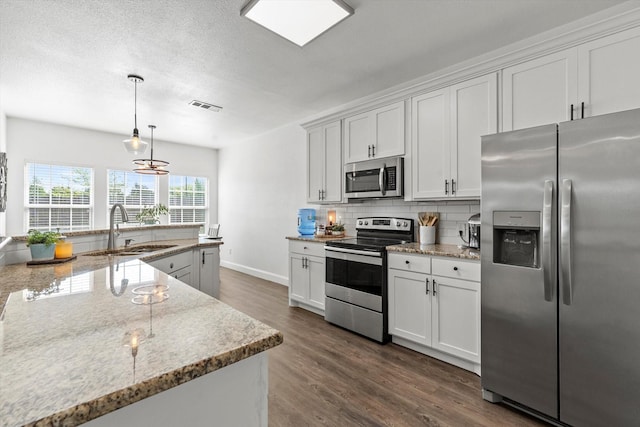 kitchen with tasteful backsplash, visible vents, a sink, dark wood finished floors, and stainless steel appliances