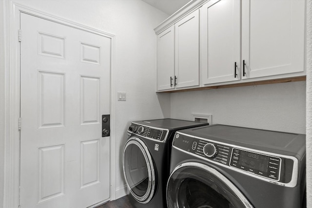laundry room featuring separate washer and dryer and cabinet space