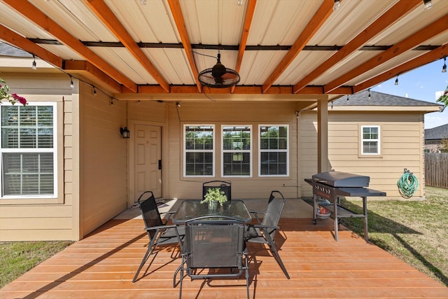 wooden terrace featuring fence, outdoor dining area, a grill, and a ceiling fan