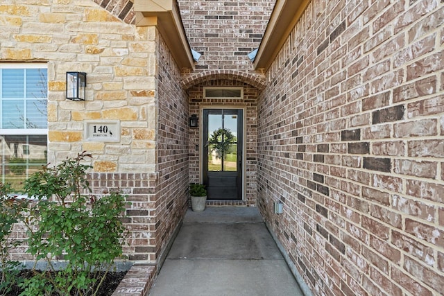 doorway to property featuring brick siding