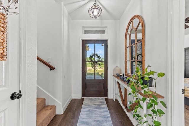 entrance foyer with stairway, dark wood-style flooring, baseboards, and lofted ceiling