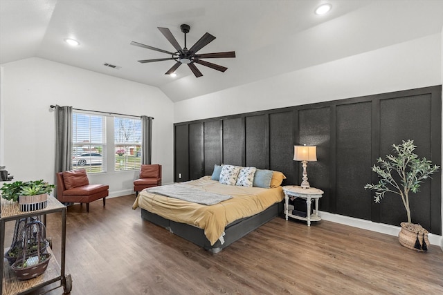 bedroom featuring visible vents, wood finished floors, and vaulted ceiling