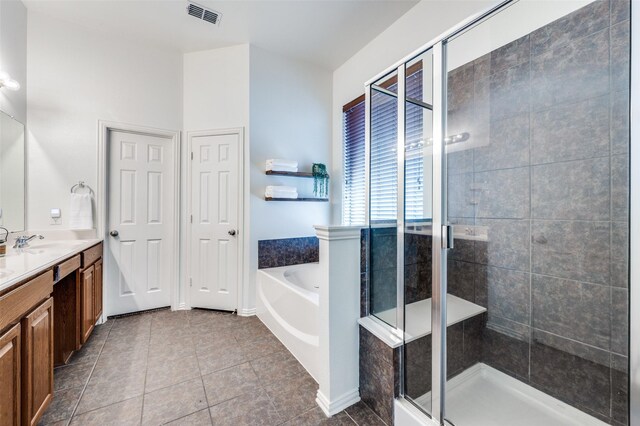 full bathroom featuring a shower stall, vanity, a garden tub, and tile patterned floors