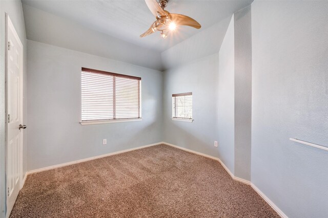 carpeted empty room with ceiling fan and baseboards