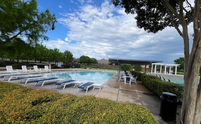 community pool featuring a patio and fence