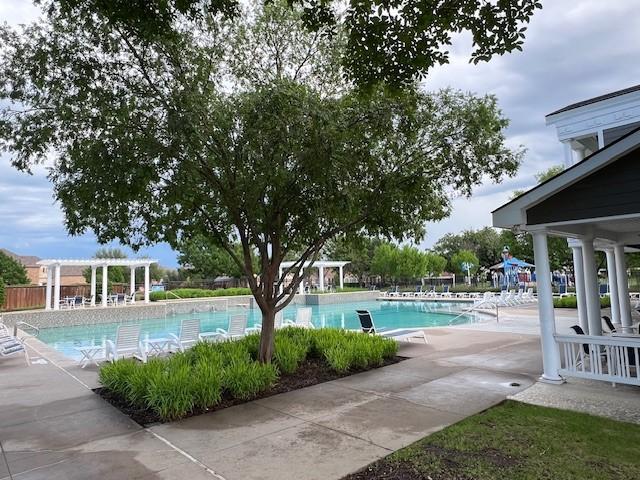 community pool with a pergola and a patio