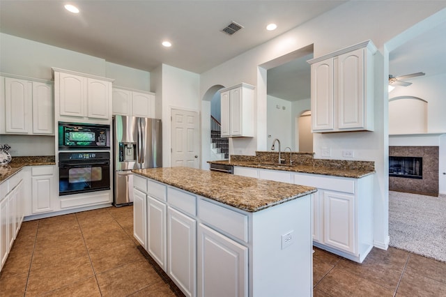 2612 Katie Trl, Melissa, TX 75454 - kitchen featuring black appliances, a sink, a kitchen island, arched walkways, and white cabinetry