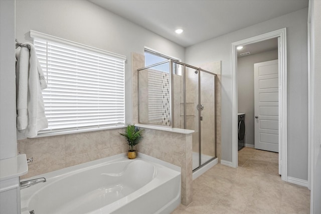 3506 Riley St, Fate, TX 75087 - bathroom with a shower stall, washer / dryer, tile patterned floors, and a garden tub
