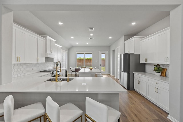 3506 Riley St, Fate, TX 75087 - kitchen with light countertops, wood finished floors, freestanding refrigerator, a peninsula, and tasteful backsplash