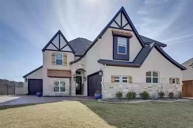 9812 El Colina Dr, Fort Worth, TX 76179 - view of front of property with a garage, stucco siding, stone siding, and fence