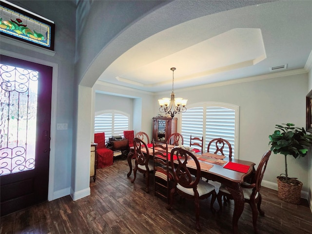 9812 El Colina Dr, Fort Worth, TX 76179 - dining area with dark wood-type flooring, a raised ceiling, arched walkways, and an inviting chandelier