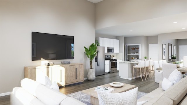 living room featuring dark wood finished floors, baseboards, a high ceiling, and recessed lighting