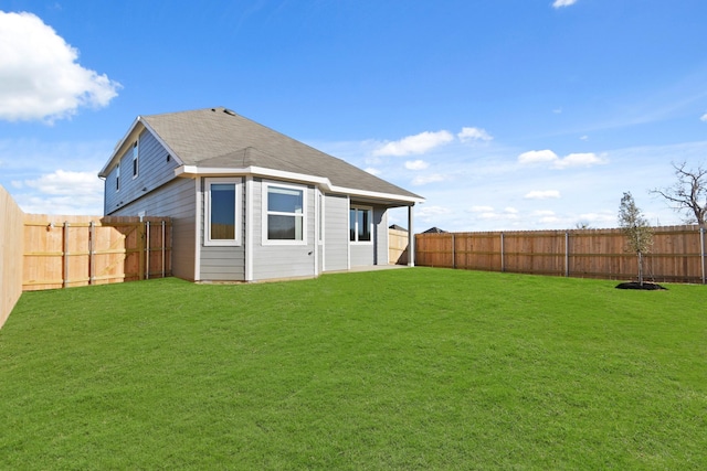 back of house featuring a lawn and a fenced backyard