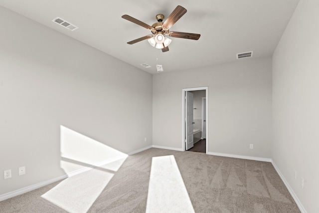 spare room featuring baseboards, carpet floors, a ceiling fan, and visible vents