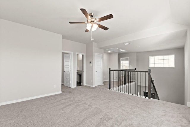 spare room featuring a ceiling fan, baseboards, and carpet