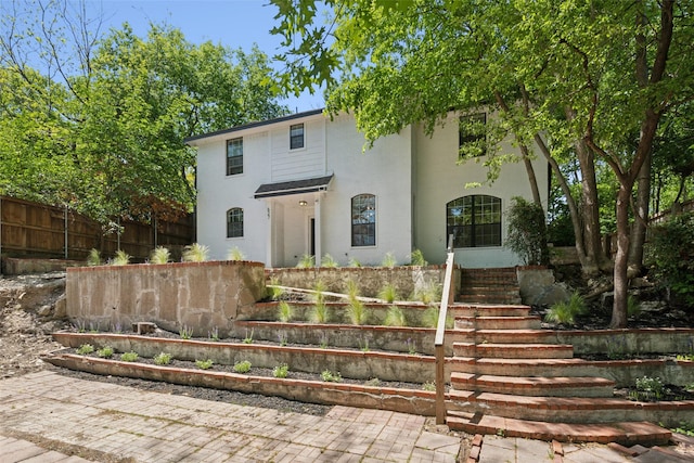 627 N Hampton Rd, Dallas, TX 75208 - view of front of property featuring fence, stairway, and stucco siding