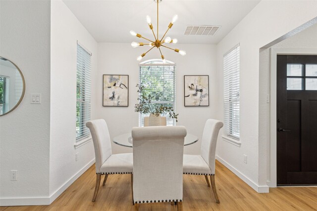 627 N Hampton Rd, Dallas, TX 75208 - dining room with a chandelier, light wood-type flooring, and baseboards